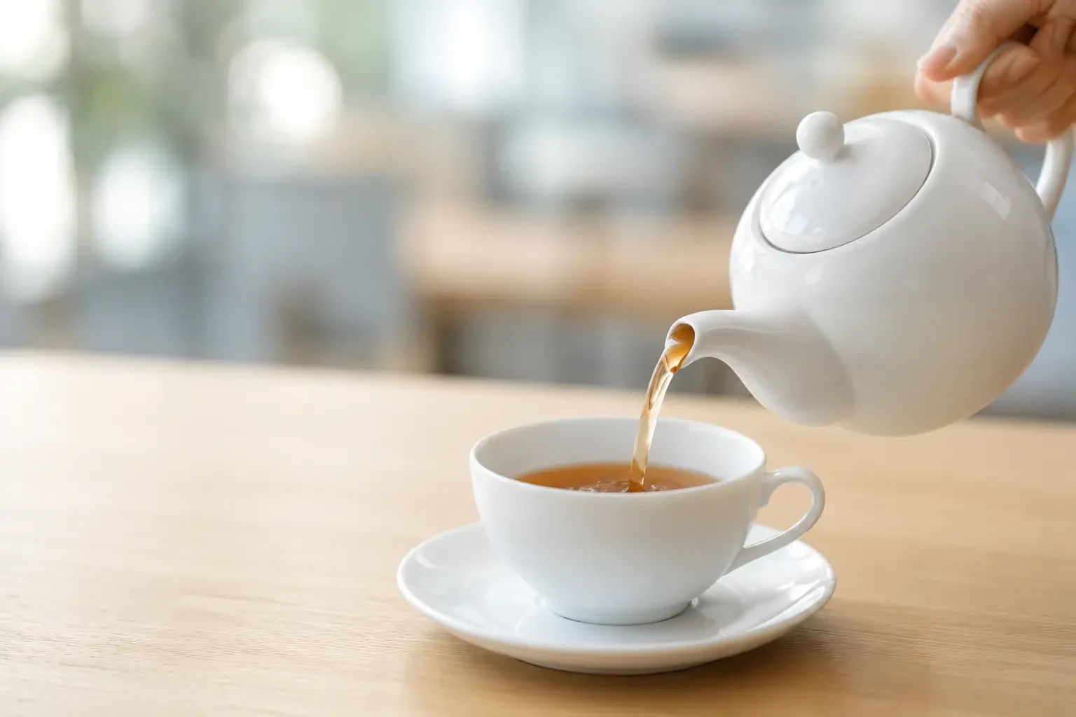 Pouring tea from a teapot in a lounge